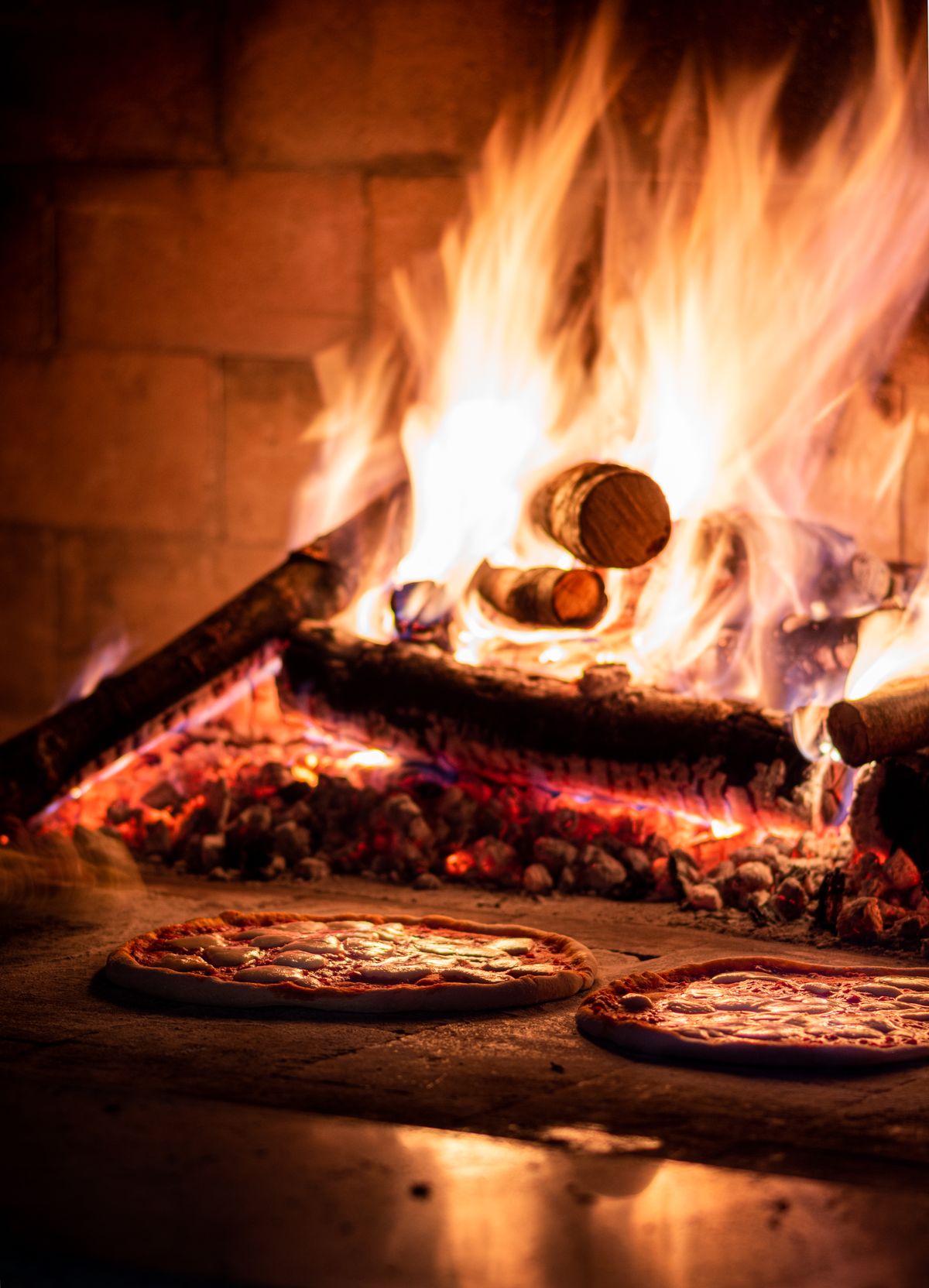 Pizzas cooking in the wood fired oven